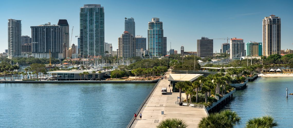St. Petersburg Florida waterfront with St. Pete Pier, palm trees, and downtown skyline under a sunny sky