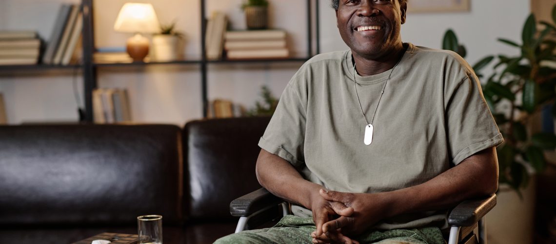 Mature african american war veteran with disability posing at therapist office smiling at camera